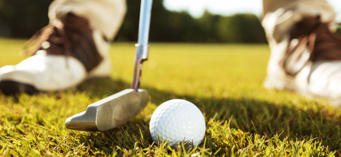 Close-up of male golfer teeing off